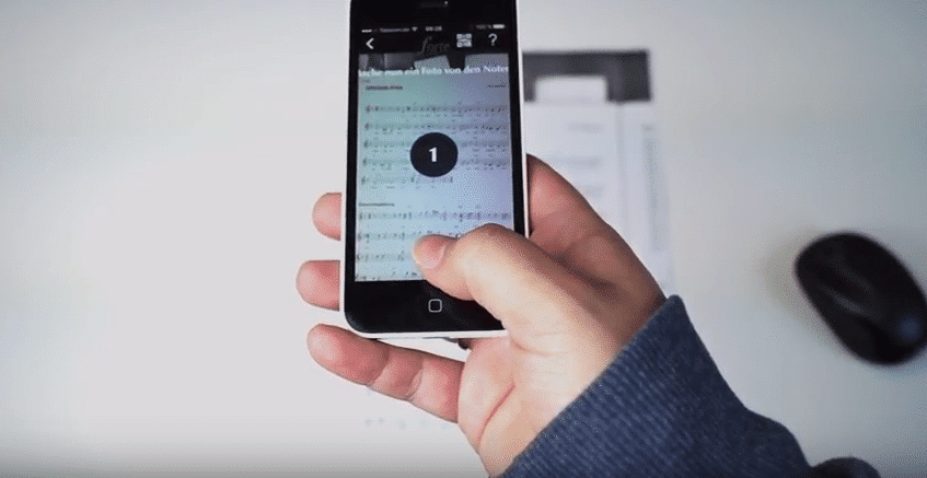 using a music scan app to take a photo of sheet music on a smartphone